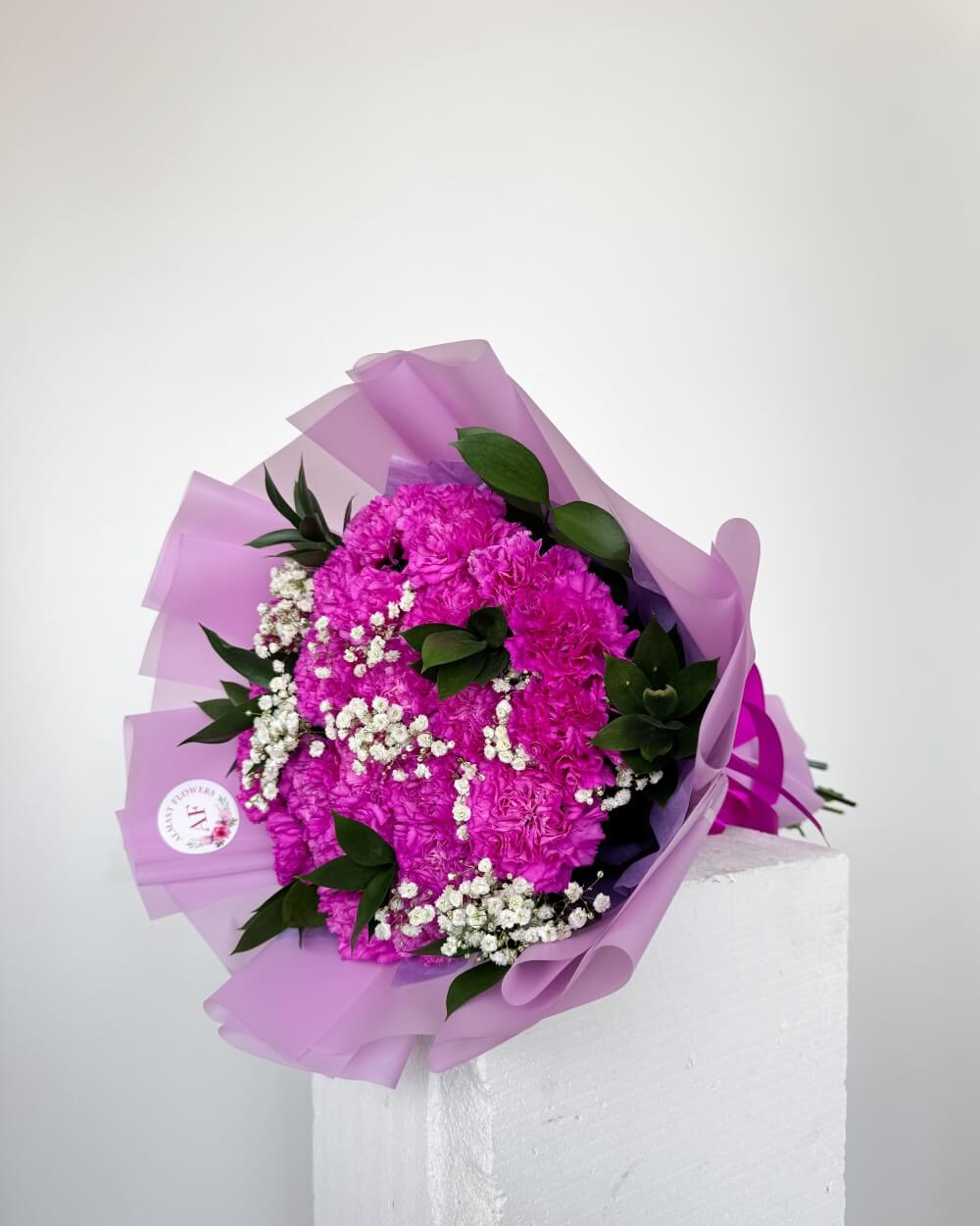 Kytice fialových karafiátů s gypsofilou a ruscusem