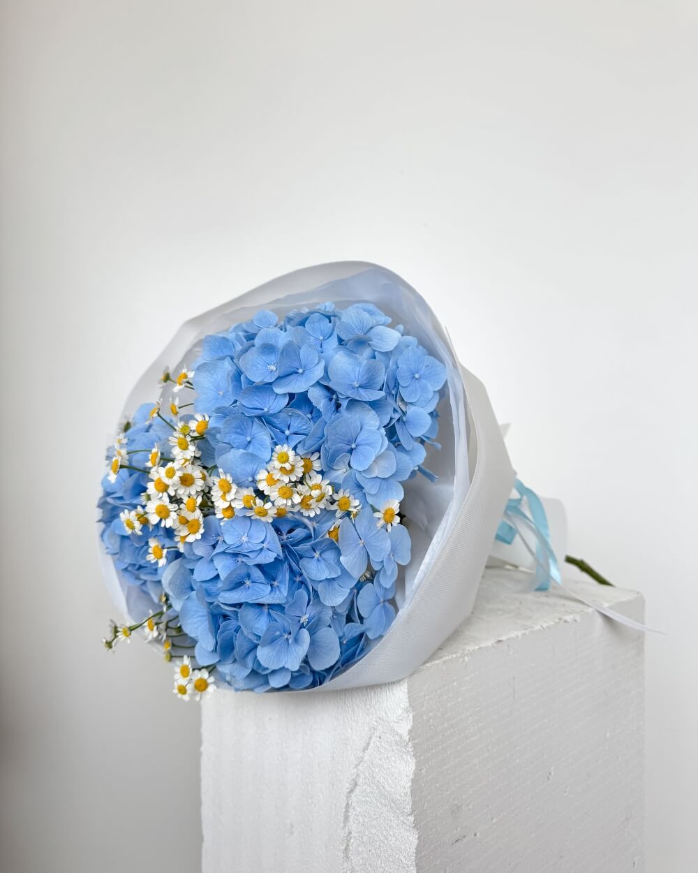 Kytice modrých hortenzií s heřmánkem