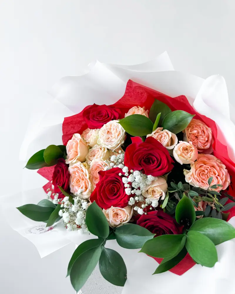 Kytice červených růží a světlých trsových růží