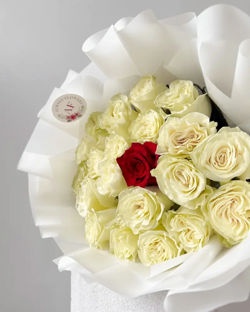 Kytice bílých růží s červenou růží uprostřed