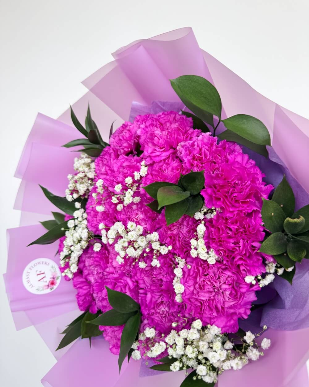 Kytice fialových karafiátů s gypsofilou a ruscusem