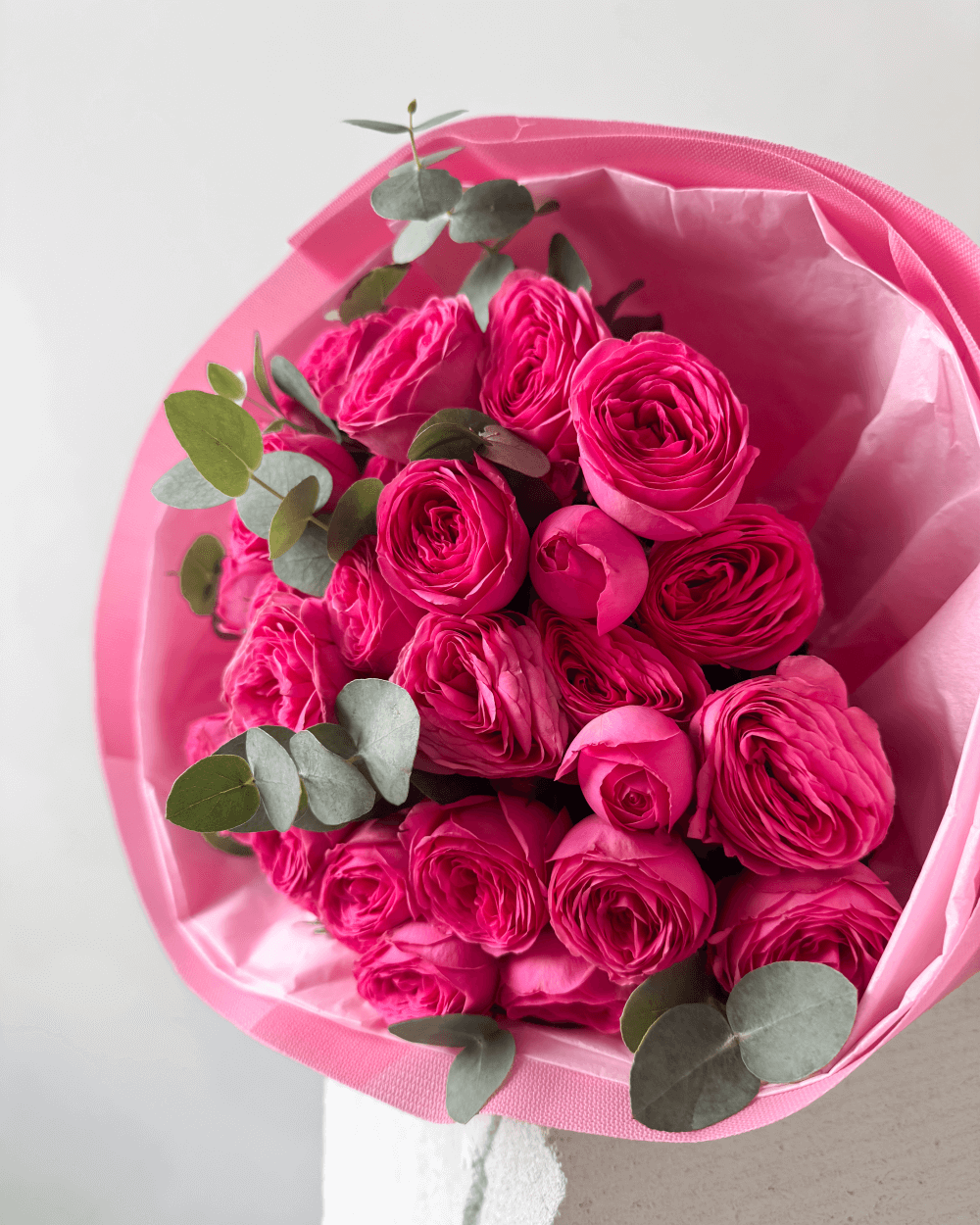 Kytice růžových trsových růží s eukalyptem