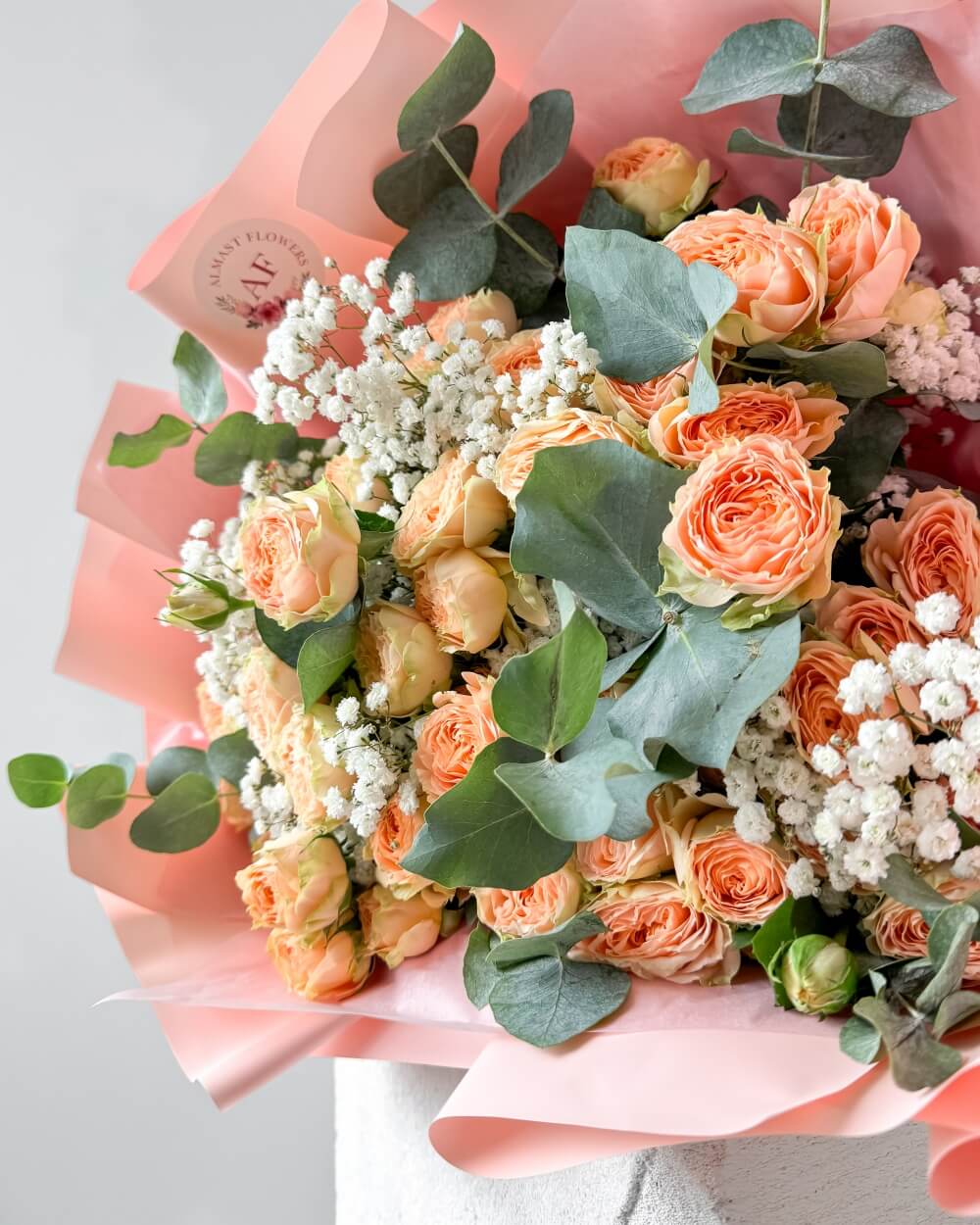 Kytice meruňkových trsových růží s gypsofilou