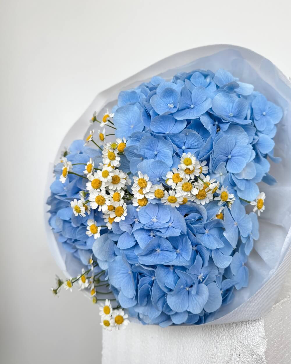Kytice modrých hortenzií s heřmánkem