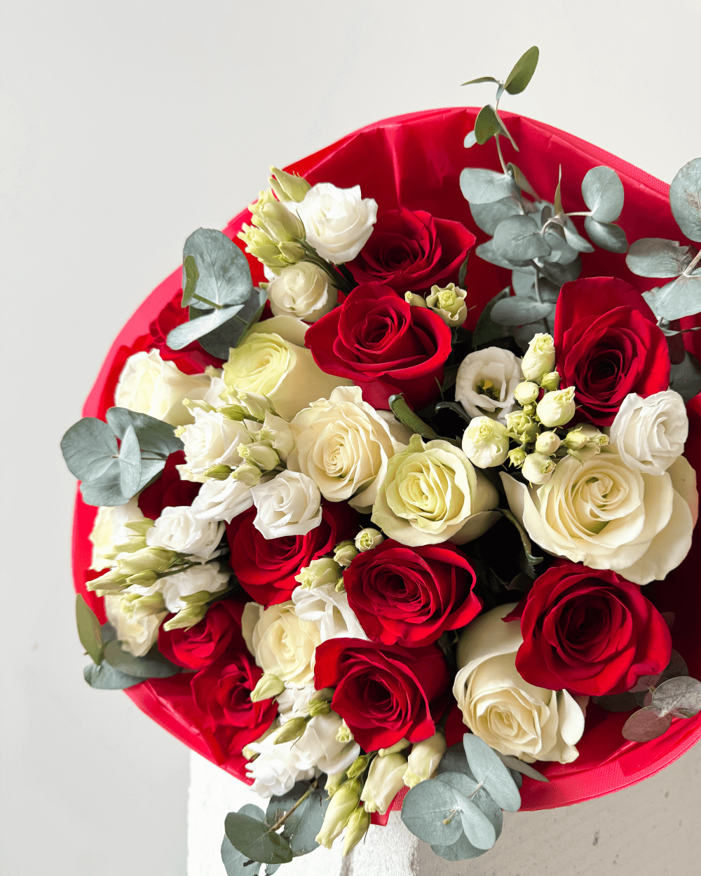 Kytice červených a bílých růží s eustomou