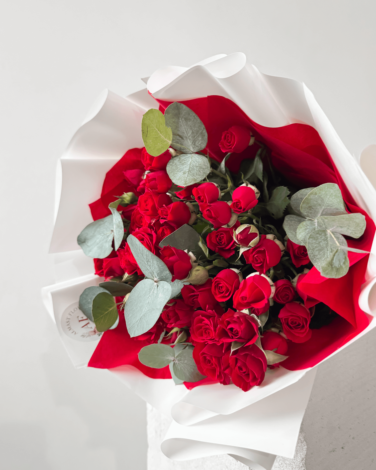 Kytice červených trsových růží s eukalyptem