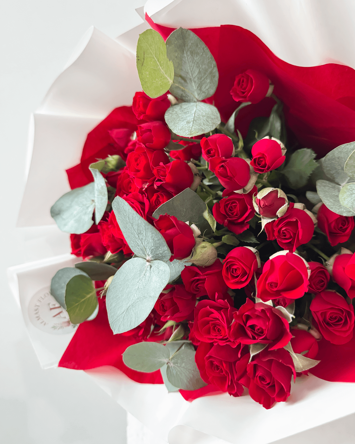 Kytice červených trsových růží s eukalyptem