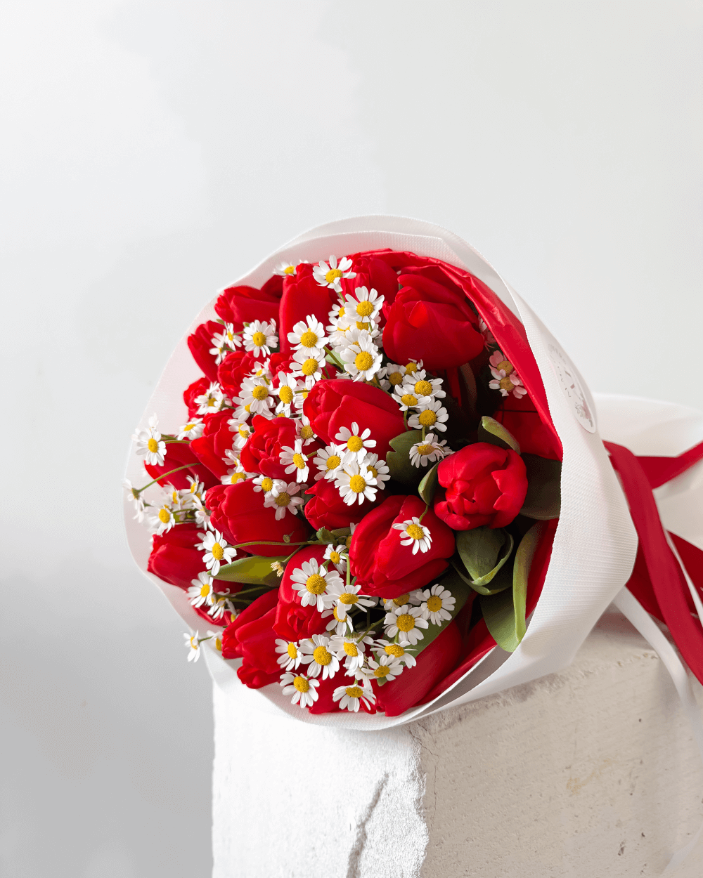 Kytice červených tulipánů s heřmánkem